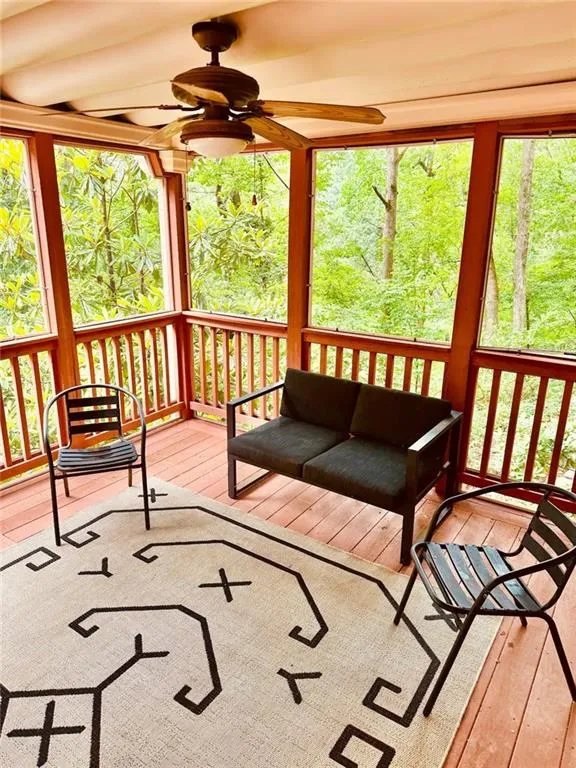 Wooden deck featuring ceiling fan and outdoor lounge area