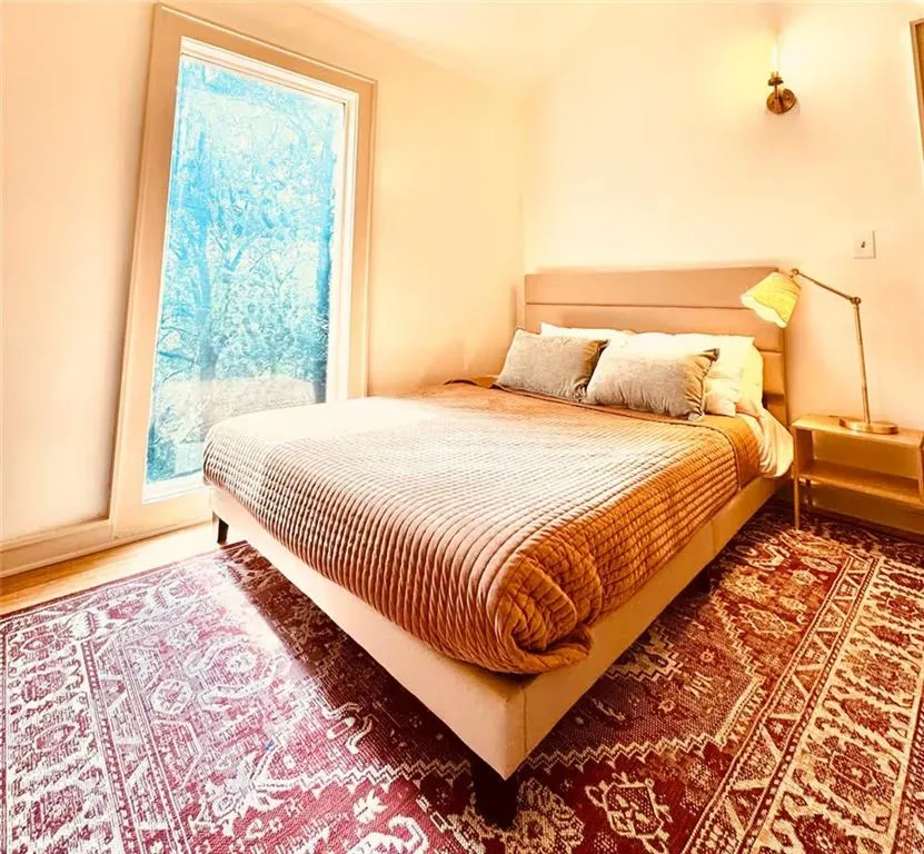 Bedroom with lofted ceiling and wood finished floors