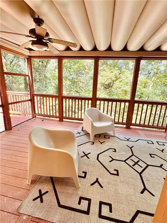 Sunroom / solarium featuring a ceiling fan, healthy amount of natural light, and hardwood / wood-style floors