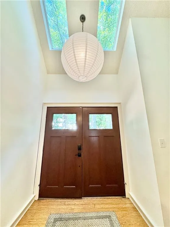 Entryway featuring a skylight and wood finished floors