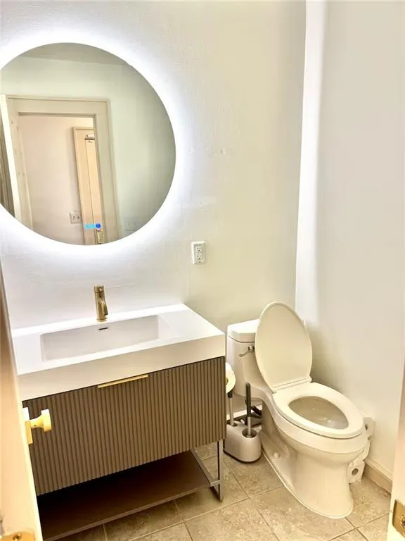 Half bathroom featuring vanity and tile patterned floors