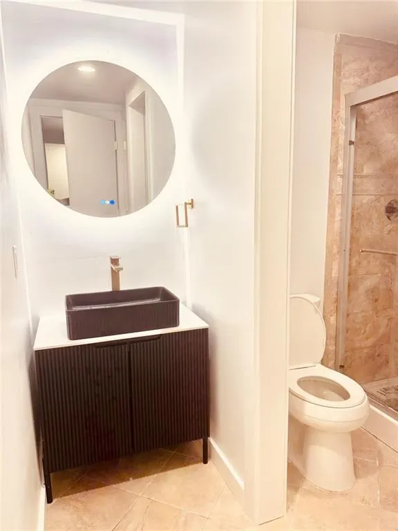 Bathroom featuring a stall shower, tile patterned floors, and vanity