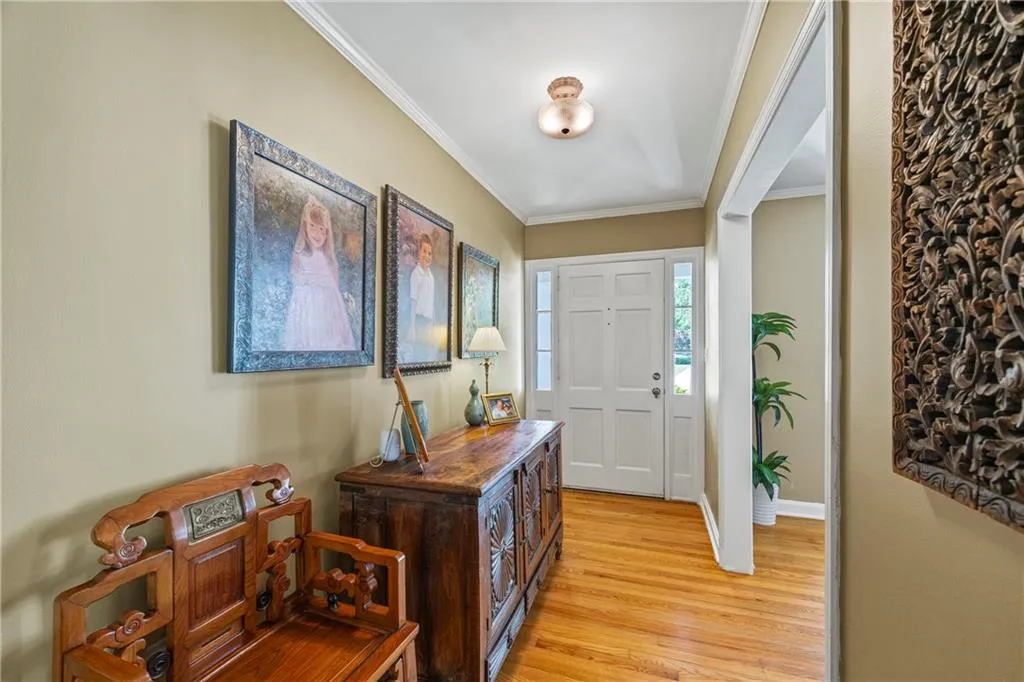 Entrance foyer featuring light wood-style flooring, baseboards, and ornamental molding