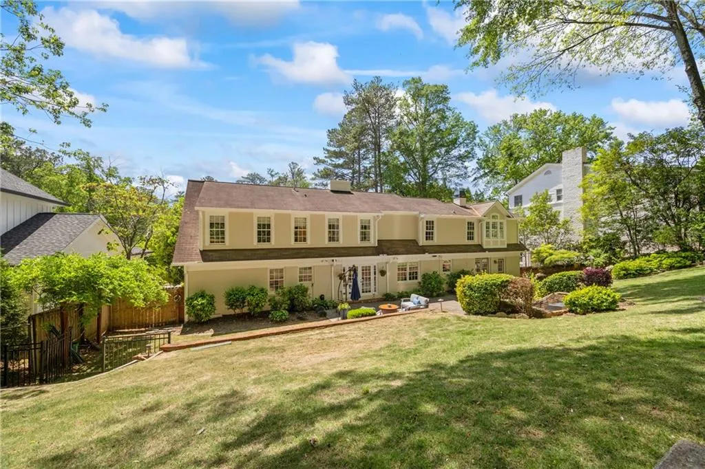 Back of property with fence and a lawn