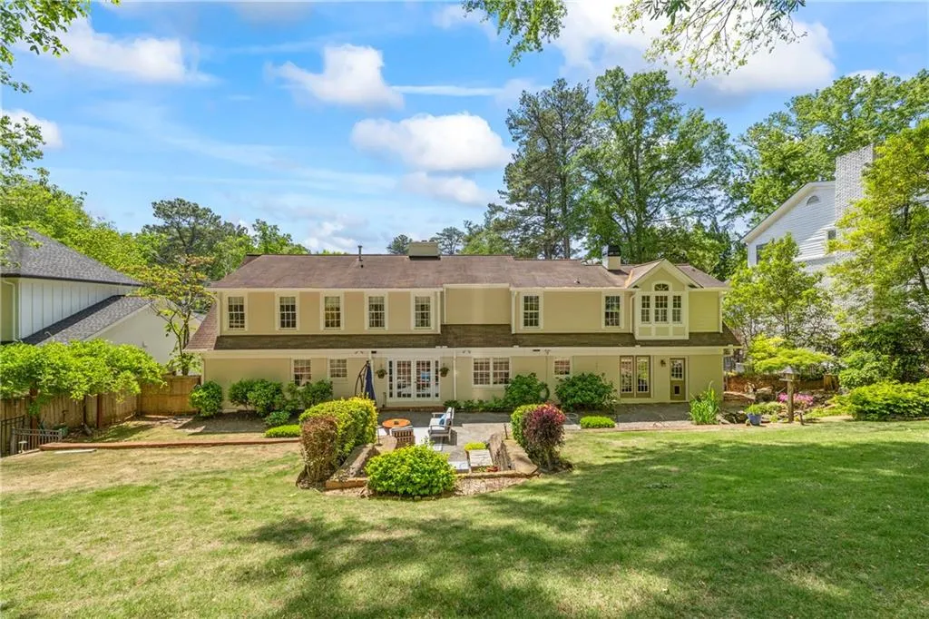 Back of property with fence, a lawn, french doors, and a patio