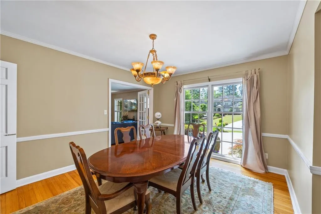 Dining area featuring baseboards, an inviting chandelier, and light wood-style flooring