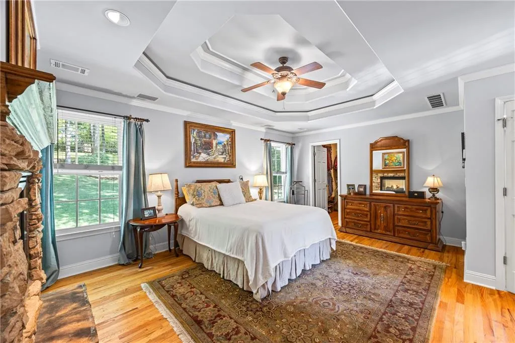 Bedroom with ornamental molding, a tray ceiling, and visible vents