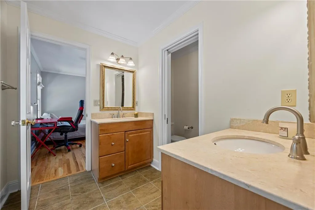 Full bathroom with toilet, crown molding, vanity, and tile patterned floors