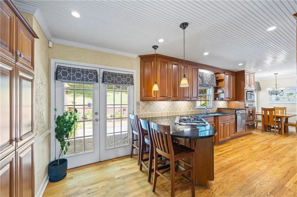 Kitchen with a peninsula, stainless steel appliances, french doors, a sink, and ornamental molding