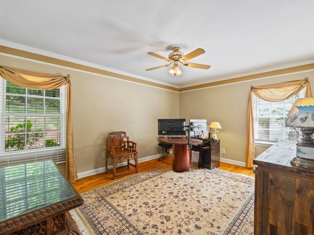 Office featuring baseboards, wood finished floors, ceiling fan, and crown molding