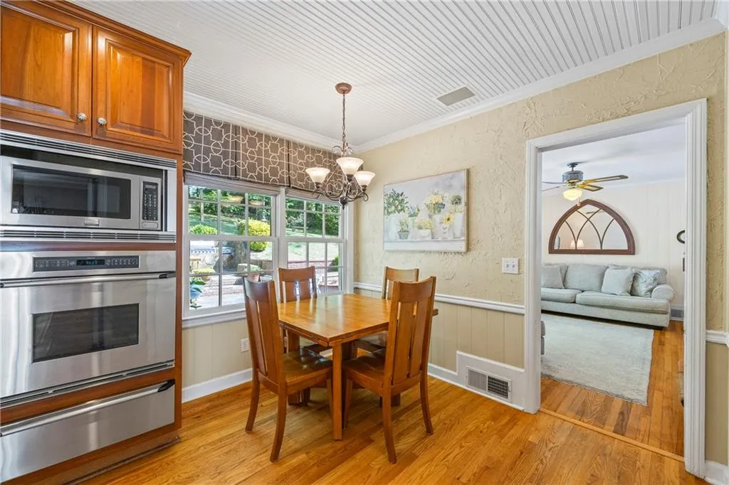 Dining space with light wood-style flooring, visible vents, and crown molding
