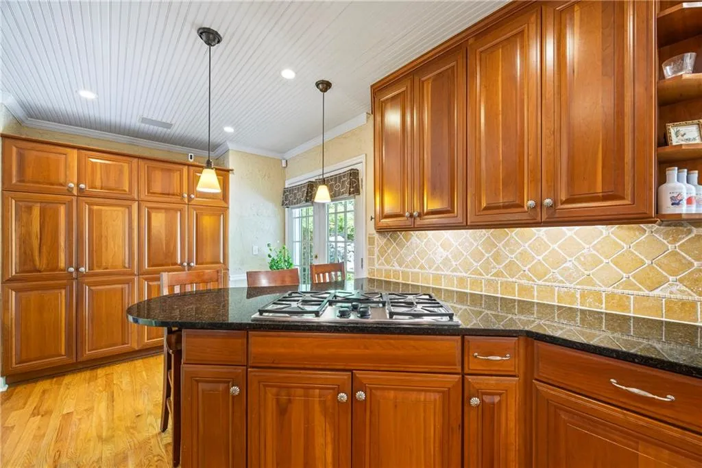 Kitchen with a peninsula, stainless steel appliances, french doors, a sink, and ornamental molding