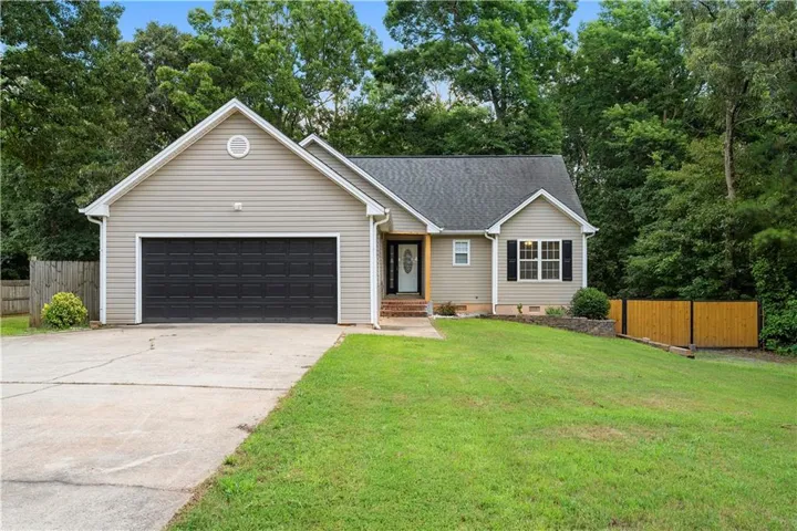 Neutral-toned siding exterior with a dark shingle roof, integrated two-car garage, and a concrete driveway