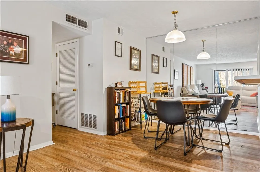Dining space with wood finished floors, visible vents, and baseboards