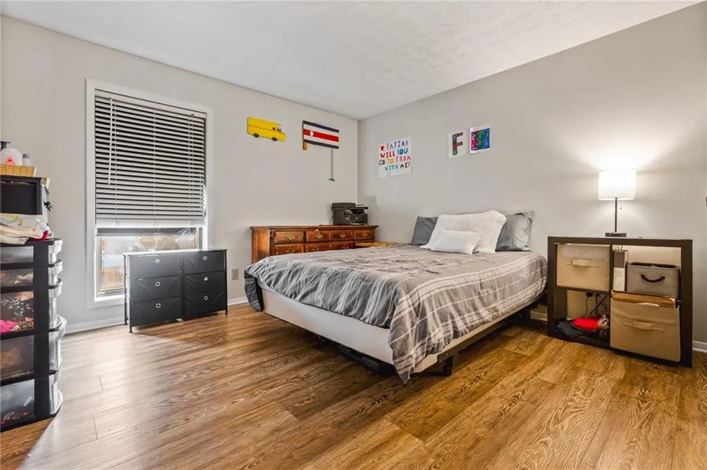 Bedroom with baseboards, a textured ceiling, and wood finished floors