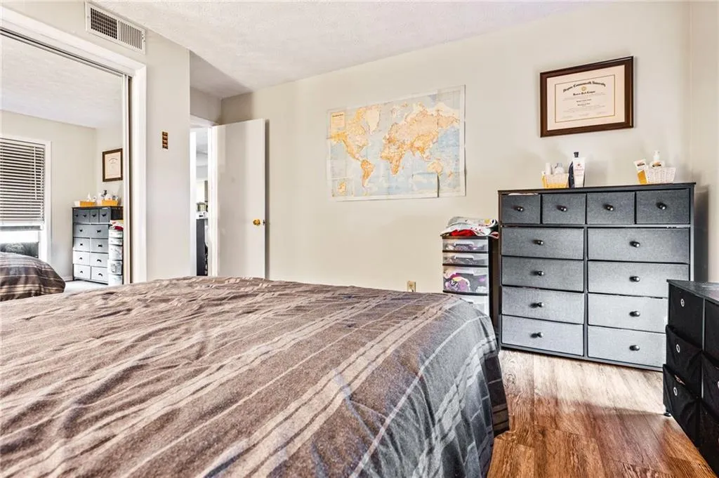 Bedroom with wood finished floors, visible vents, and a textured ceiling