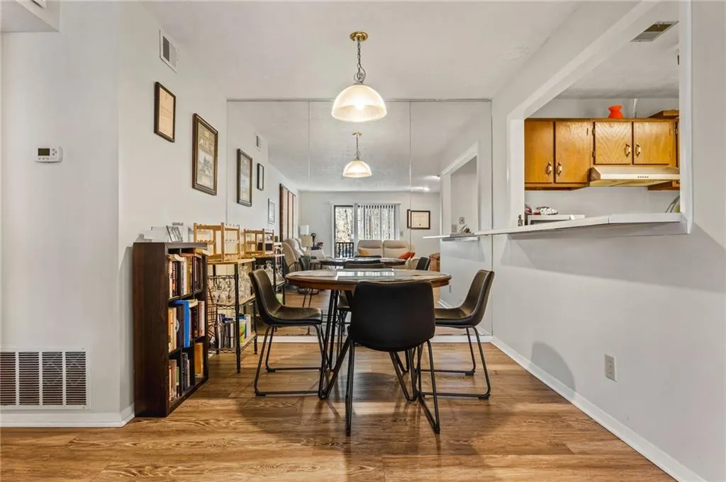 Dining space featuring wood finished floors, visible vents, and baseboards