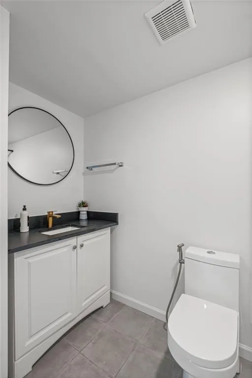 Half bath featuring vanity and light tile patterned floors