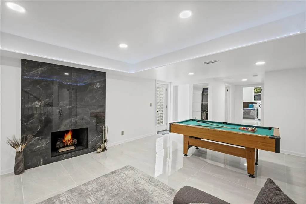 Playroom featuring billiards table, a large fireplace, recessed lighting, and tile patterned flooring