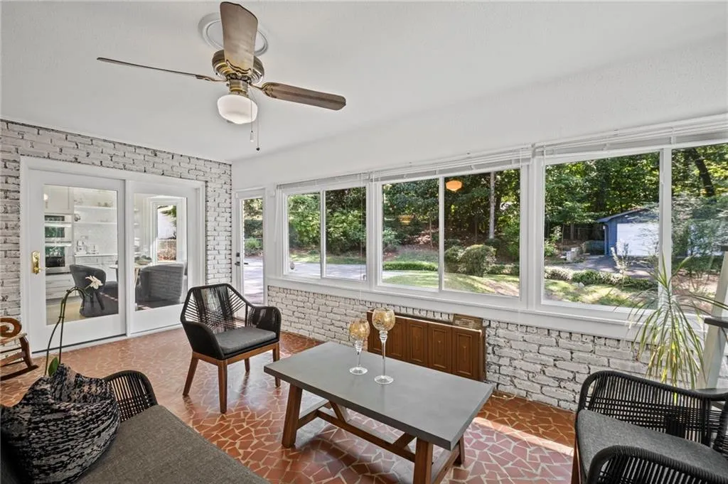 Sunroom featuring brick wall