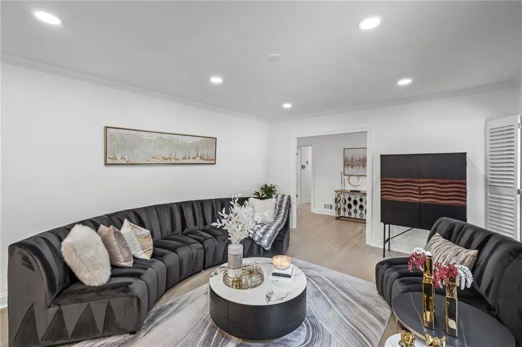 Living room with crown molding, recessed lighting, and wood finished floors