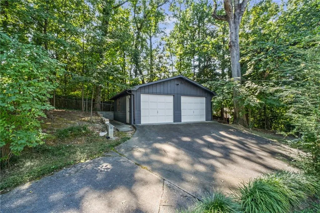 Detached garage featuring view of scattered trees