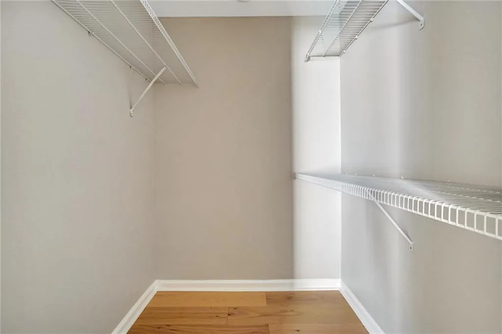 Walk in closet featuring light wood-style flooring Walk in closet featuring light wood-style flooring