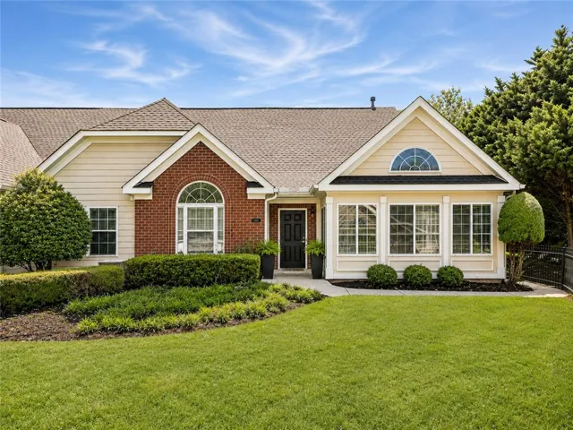 Single-story residence featuring a combination of brick and siding, an arched window, and a prominent front door
