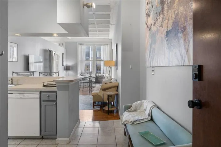 Entryway featuring a wood-finish door with a keyless entry system, leading to an open-concept living space