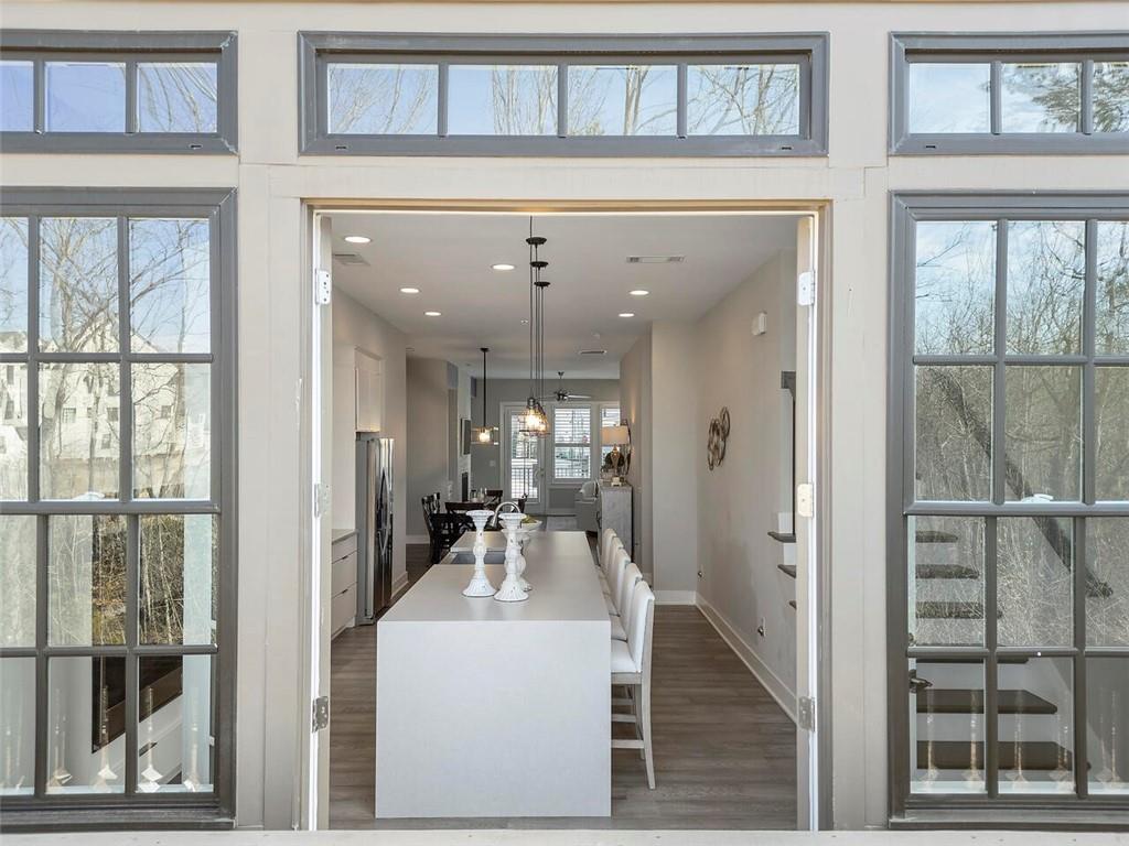 Kitchen featuring a kitchen island, hanging light fixtures, a kitchen breakfast bar, stainless steel fridge, and dark hardwood / wood-style flooring