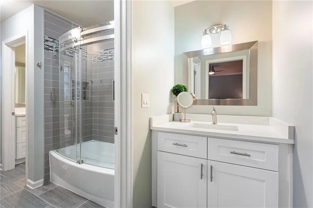 Jack & Jill bath is all renovated with sliding curved glass tub enclosure