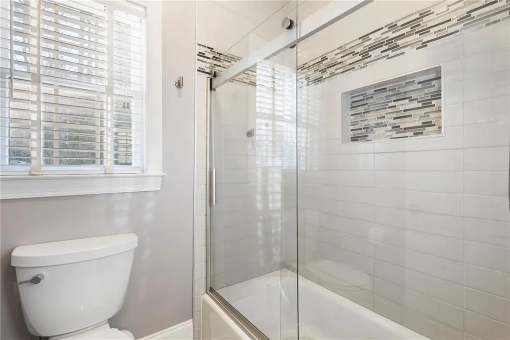 Updated bath with beautiful tiles serves as powder room for your guests.