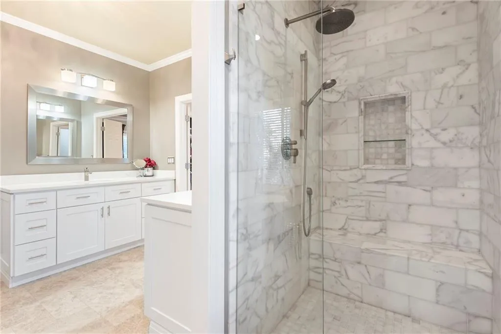 Renovated frameless glass door shower with double toiletries niche