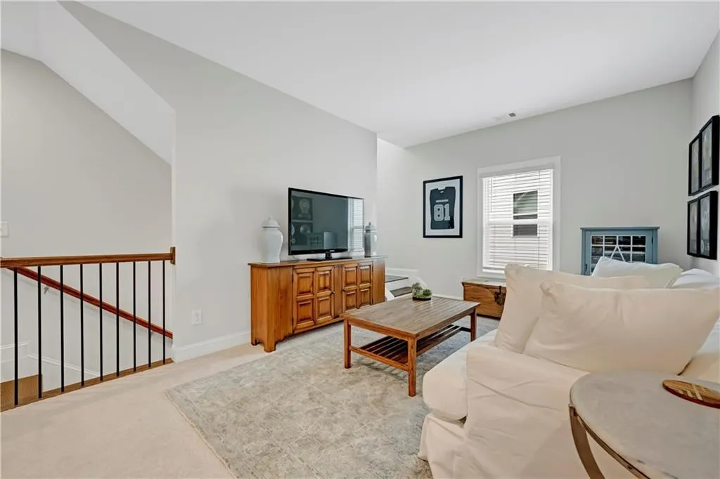 Carpeted living area featuring baseboards