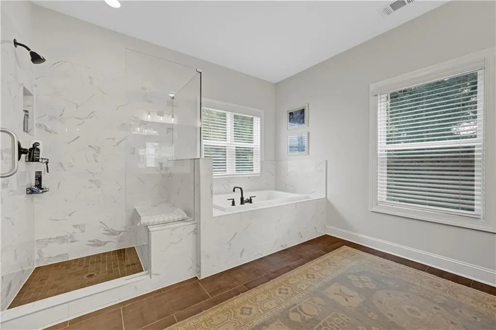 Full bath featuring a bath, a marble finish shower, and tile patterned flooring
