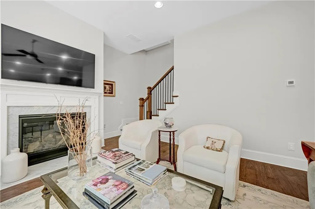 Living room featuring wood finished floors, a fireplace, stairs, recessed lighting, and a ceiling fan