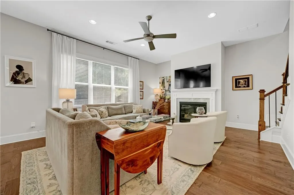 Living area featuring a fireplace, wood finished floors, ceiling fan, recessed lighting, and stairway