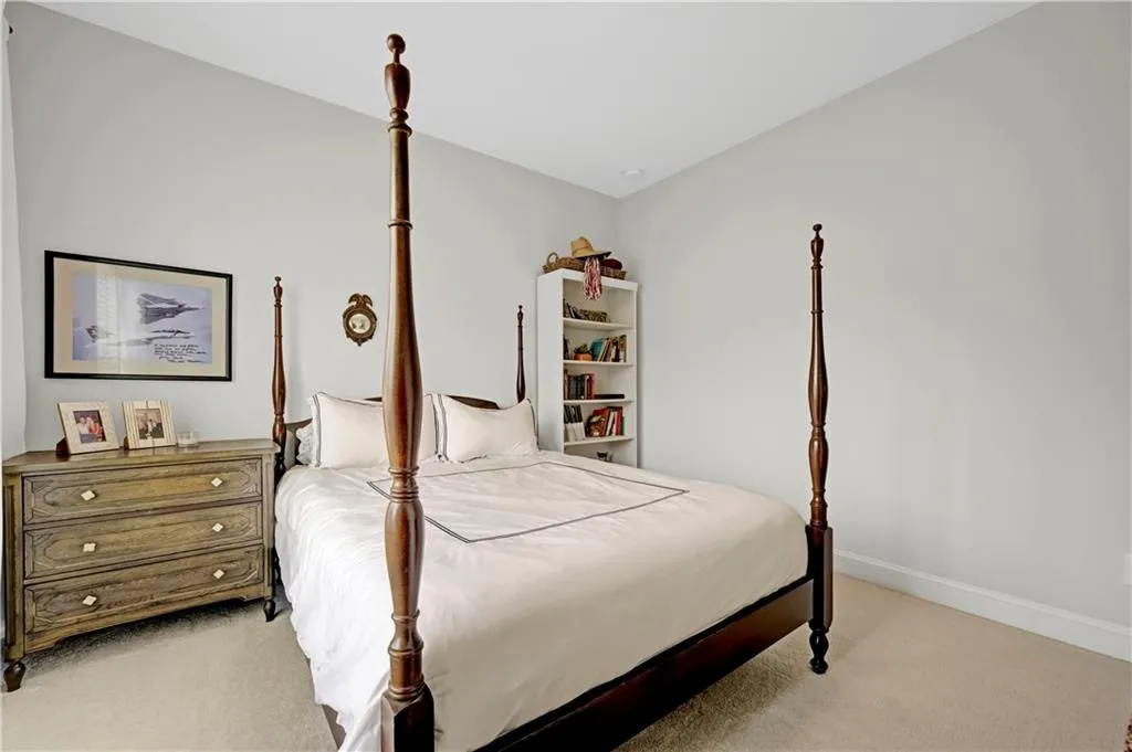 Bedroom with light colored carpet and baseboards