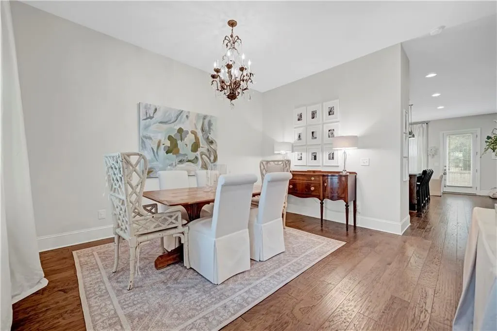 Dining space with dark wood-style floors, a chandelier, and recessed lighting