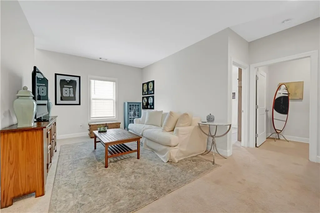 Living area with light colored carpet and baseboards