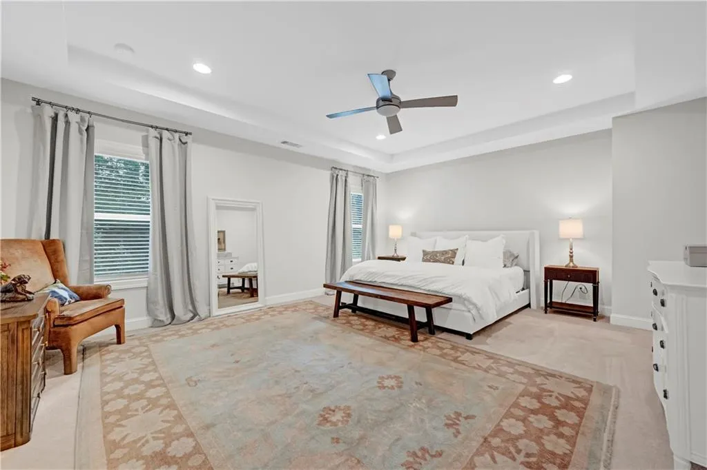 Bedroom featuring a tray ceiling, a ceiling fan, and recessed lighting
