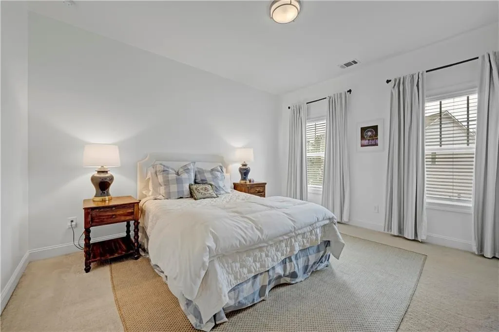 Bedroom with light colored carpet and baseboards