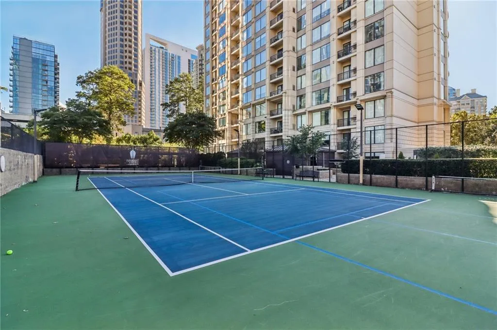 View of tennis court featuring community basketball court and a city view