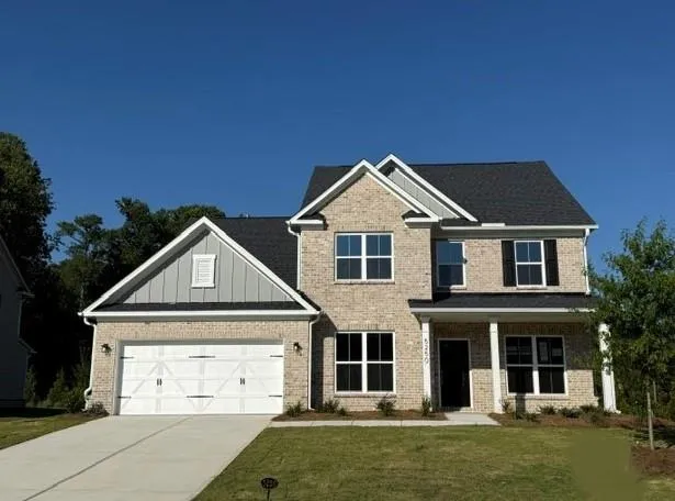 Brick facade with gabled roof lines, white trim accents, and a two-car garage