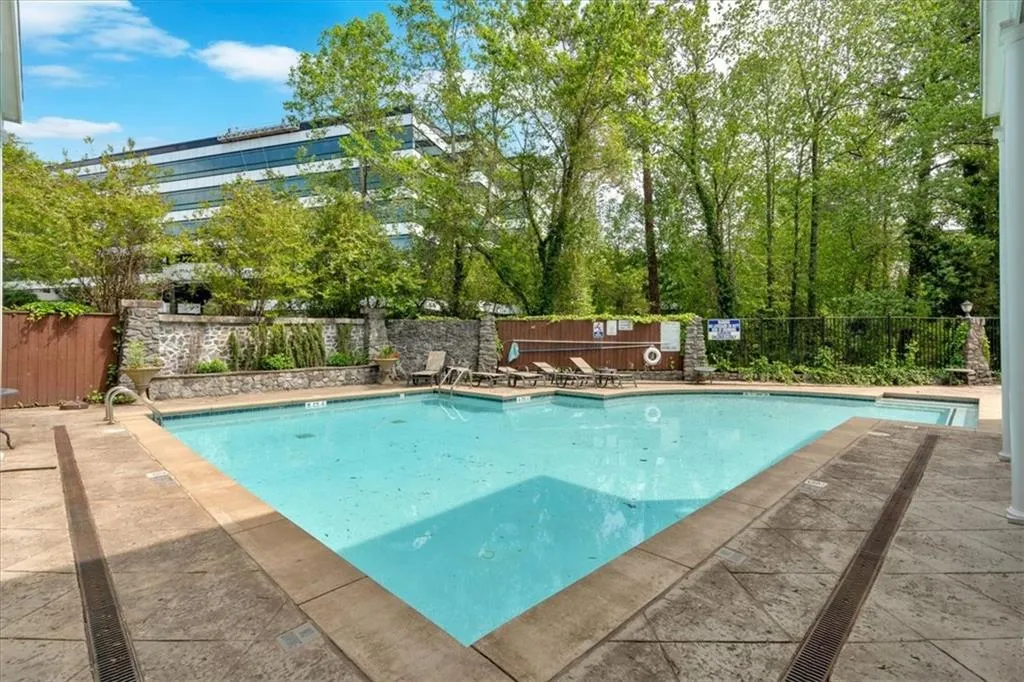 Pool with a patio and fence