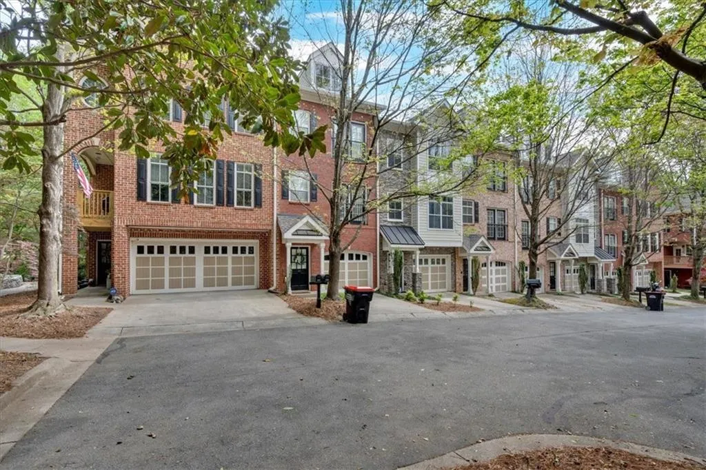 View of property featuring a garage, brick siding, and concrete driveway