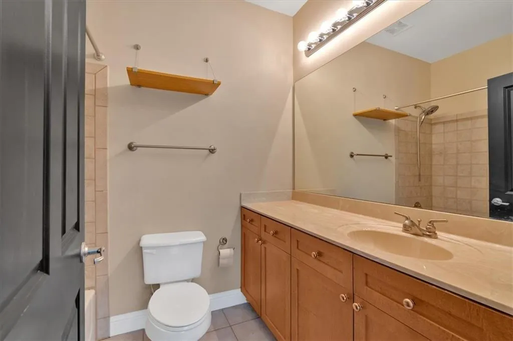 Full bathroom with visible vents, toilet, vanity, and tile patterned floors