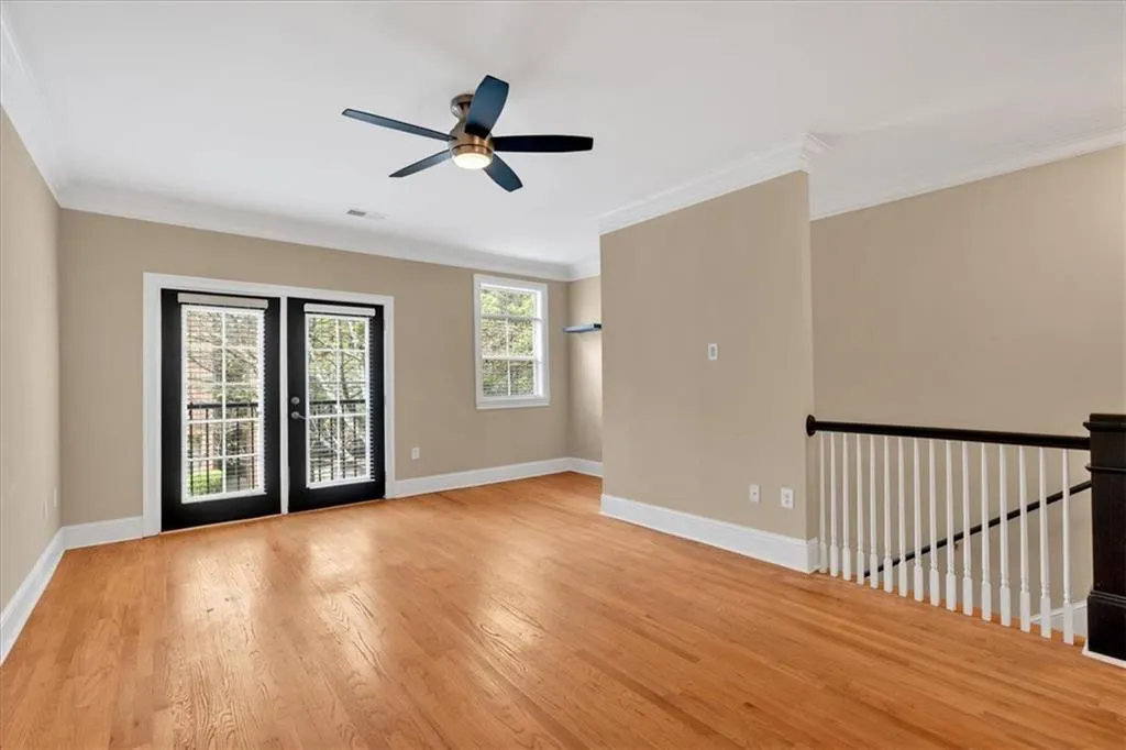 Unfurnished room with ceiling fan, baseboards, ornamental molding, and wood finished floors