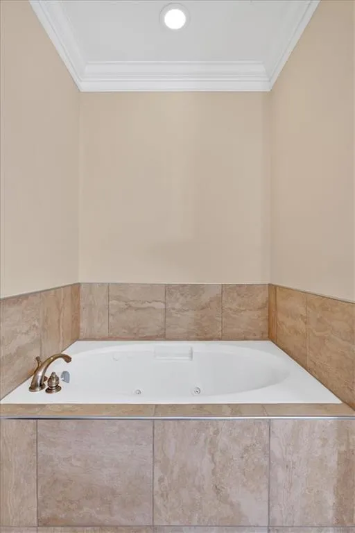 Full bathroom featuring a bath and crown molding