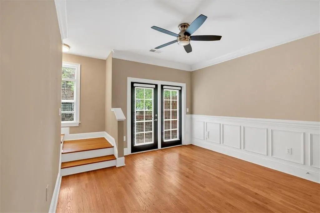 Spare room featuring light wood finished floors, visible vents, a wealth of natural light, and ceiling fan
